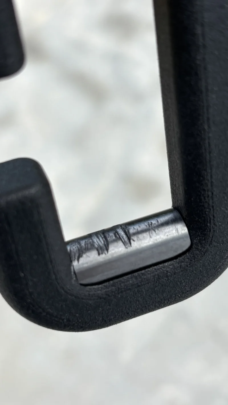Close-up of a bicycle chain roller pin after a first application of CHA Core on a clean chain.
